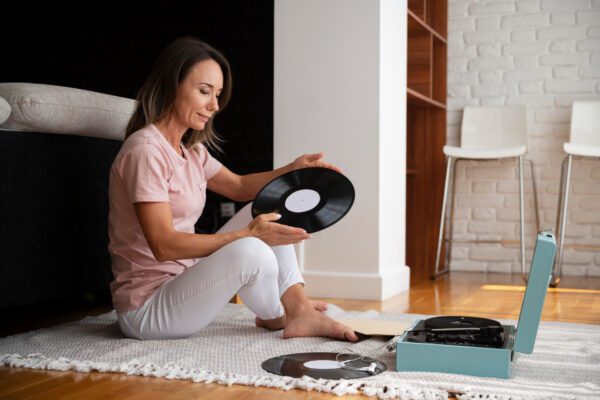 Sugrįžusi muzikinė klasika: kodėl vinilas vėl užkariauja širdis Vinilo patefonas ant stalo su plokštelėmis, sukuriantis retro atmosferą